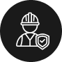 Icon of a construction worker wearing a hard hat and vest, accompanied by a shield with a checkmark, set against a dark circular background. Ideal for representing the professionalism of land surveyors in Okeechobee County.